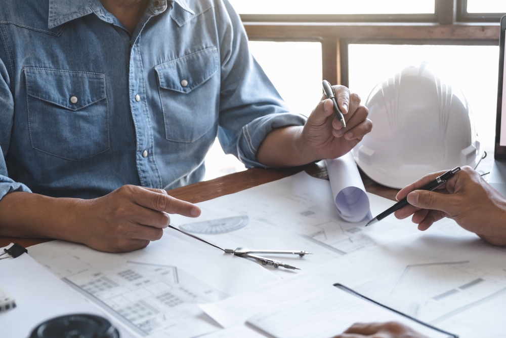 Architects,Interior,Designer,Hands,Working,With,Blue,Prints,And,Documents